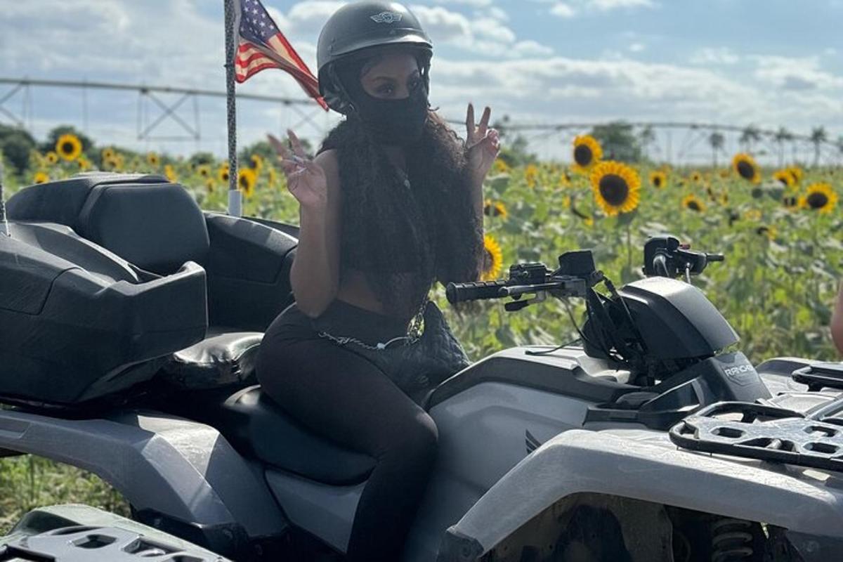 uma mulher está sentada em uma motocicleta em um campo