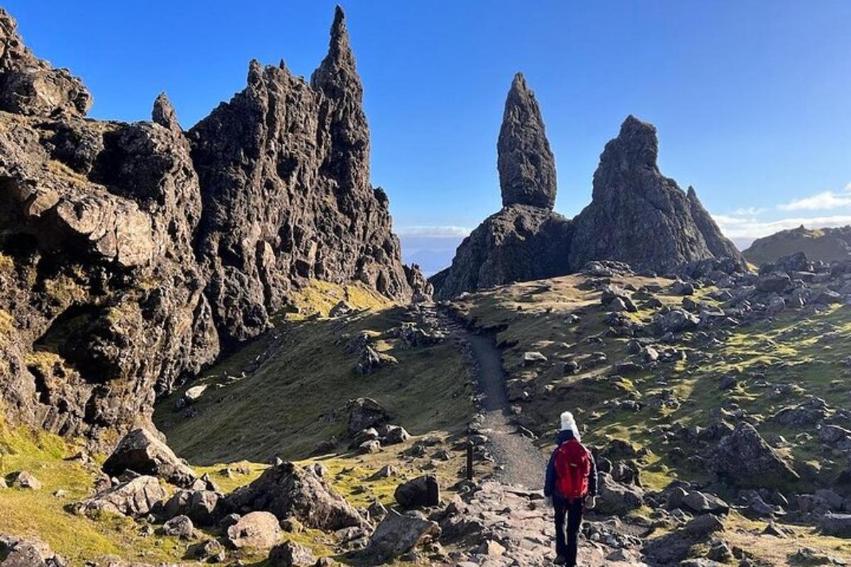 um homem caminhando em uma montanha com pedras