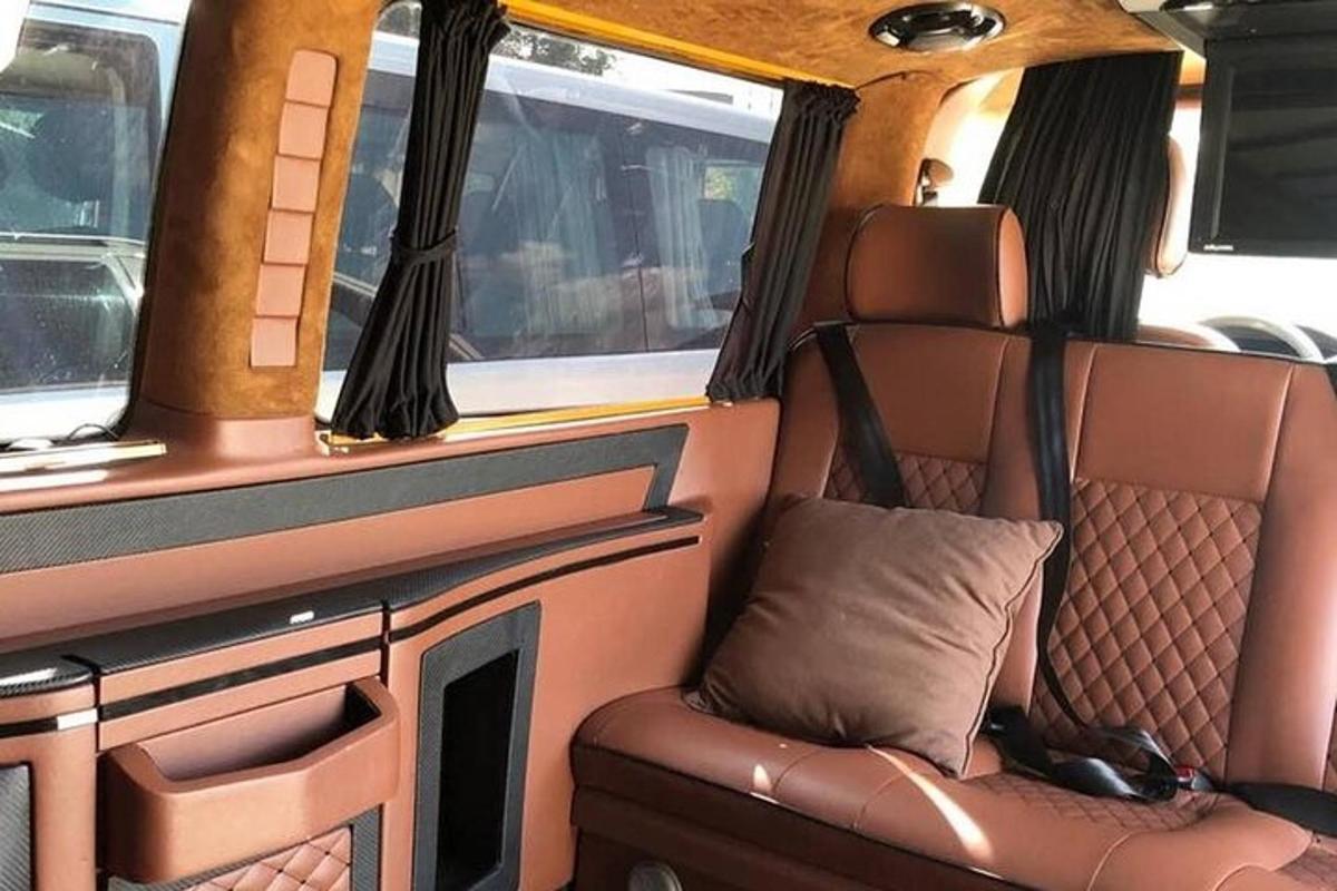 a seat in the back of a van with a dog laying on it