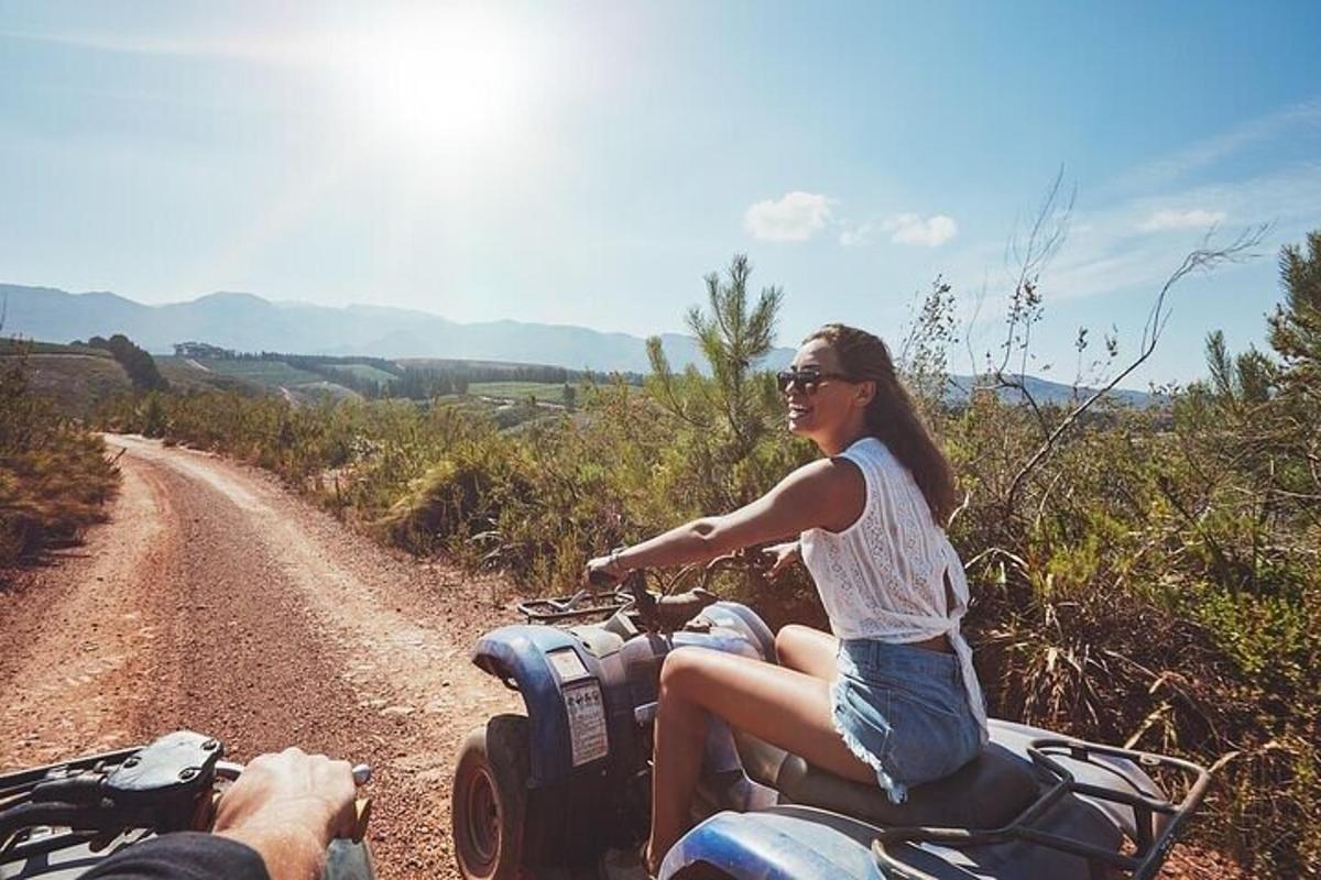 a woman riding a motorcycle on a dirt road