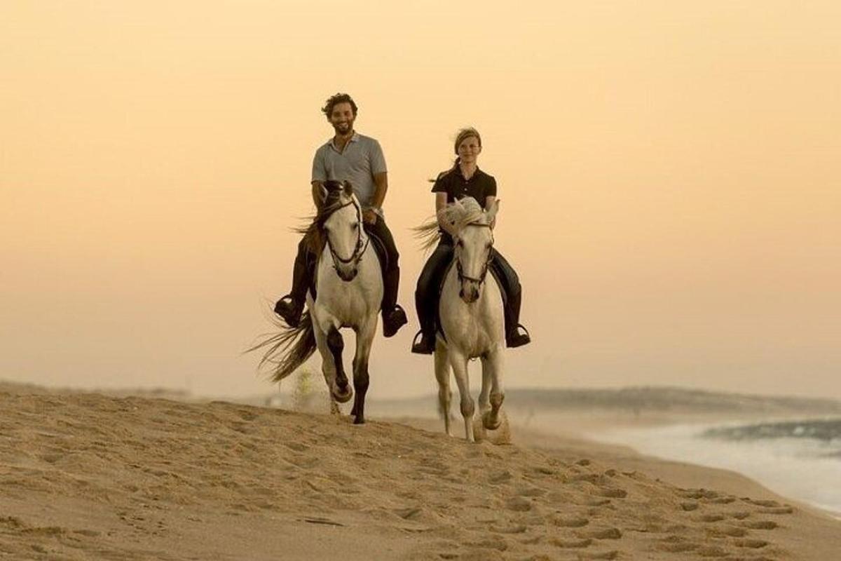 un uomo e una donna a cavallo sulla spiaggia