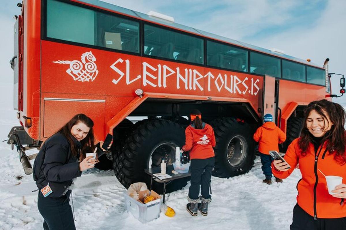 skupina lidí stojících vedle autobusu ve sněhu
