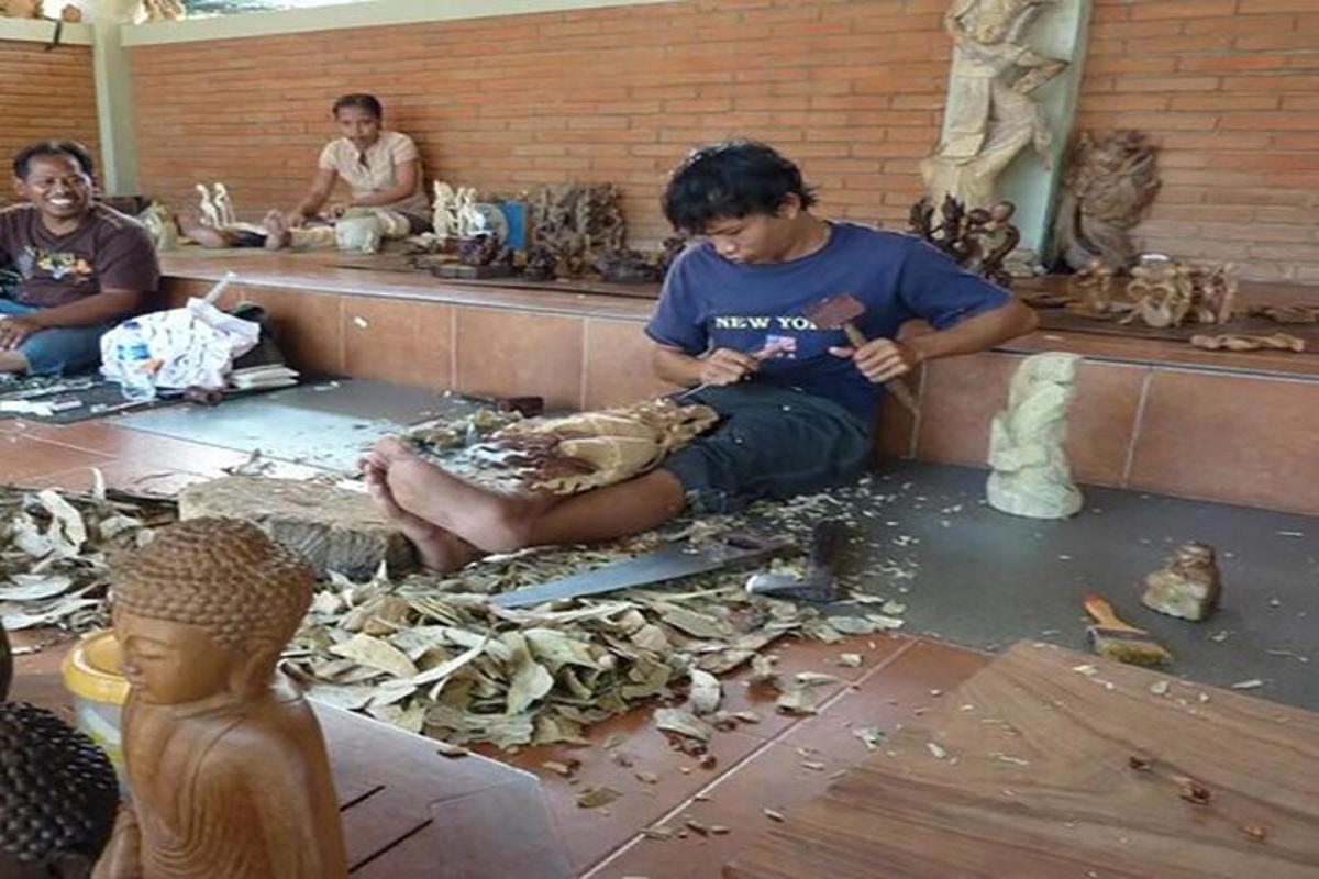 seorang lelaki duduk di atas lantai di dalam bilik yang dipenuhi dengan patung-patung