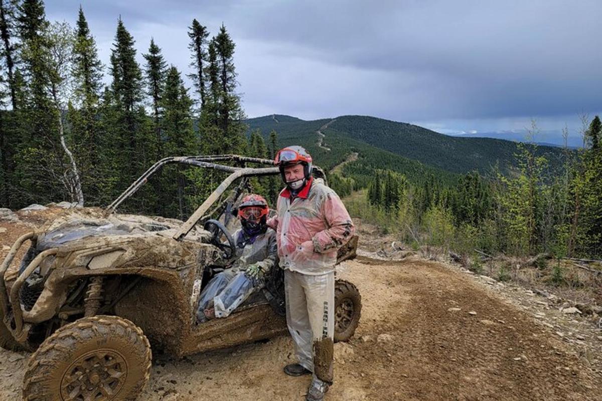 two men standing in front of a dirt truck