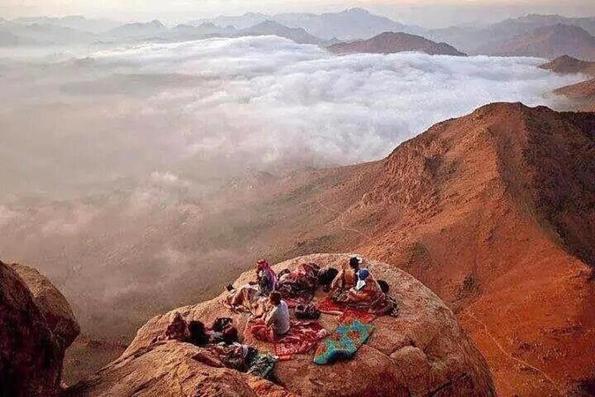 a group of people sitting on top of a mountain