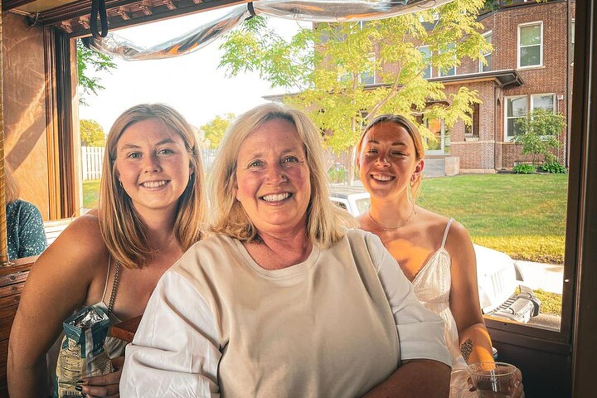 three women are posing for a picture on a porch