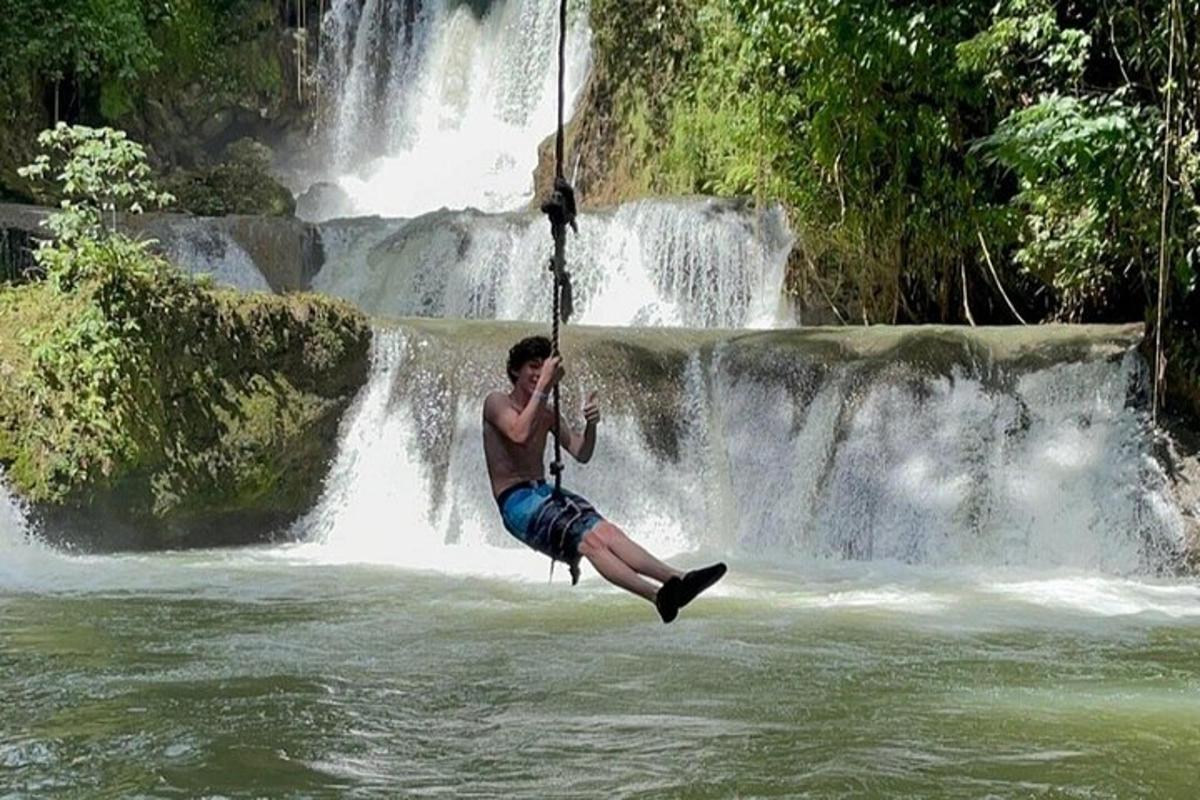 un home en un gronxador davant d'una cascada