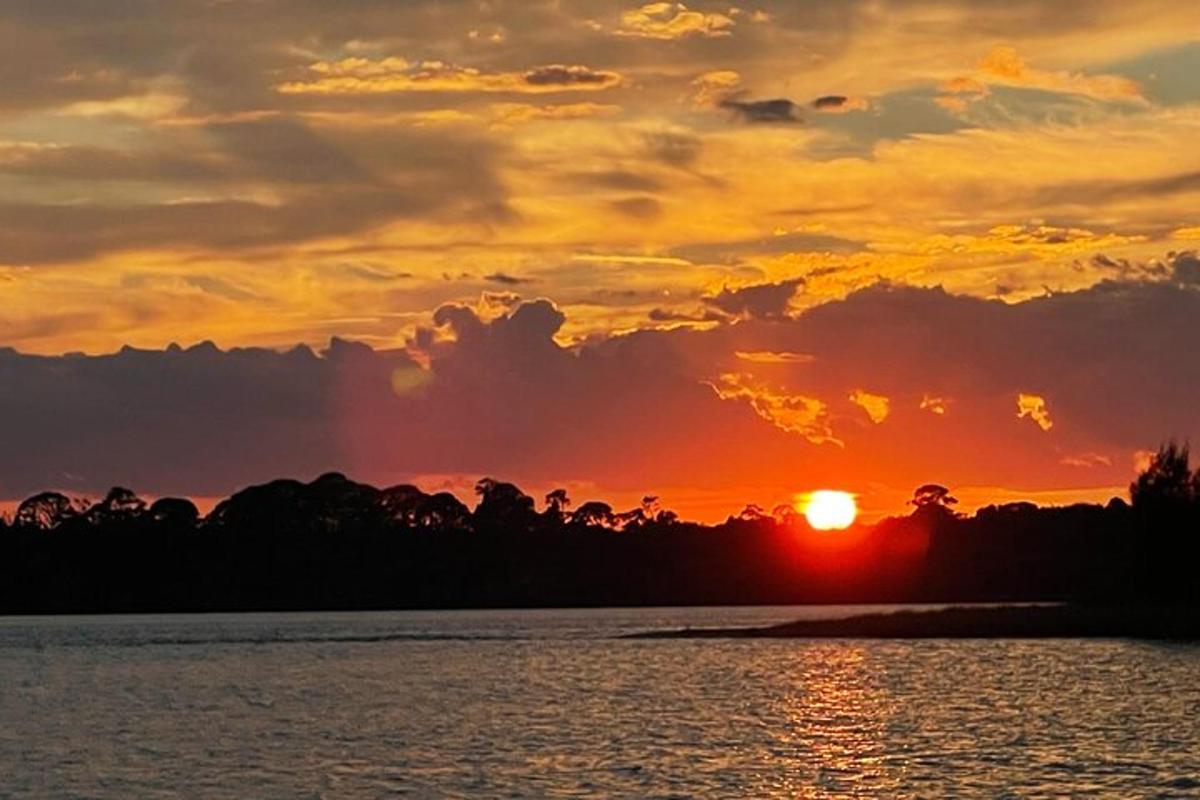 a sunset over a body of water with the sun setting
