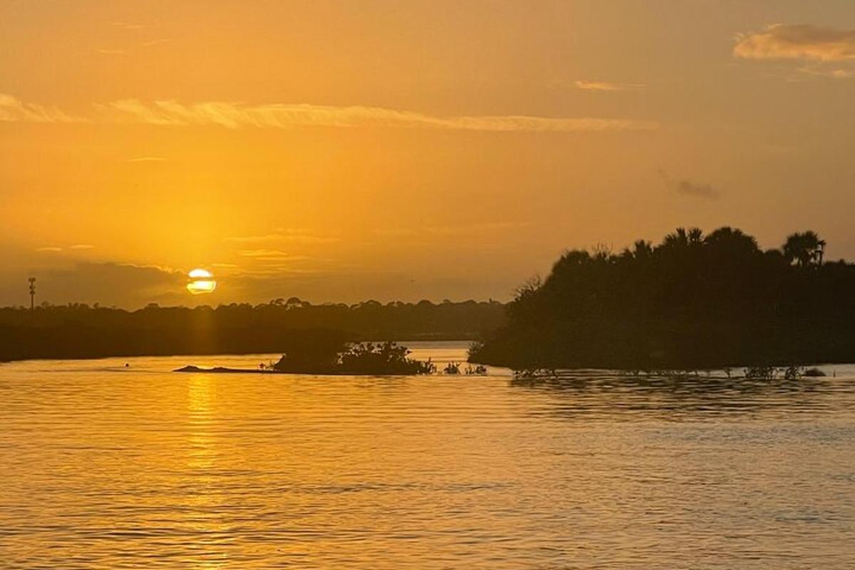 a sunset over a body of water with a island
