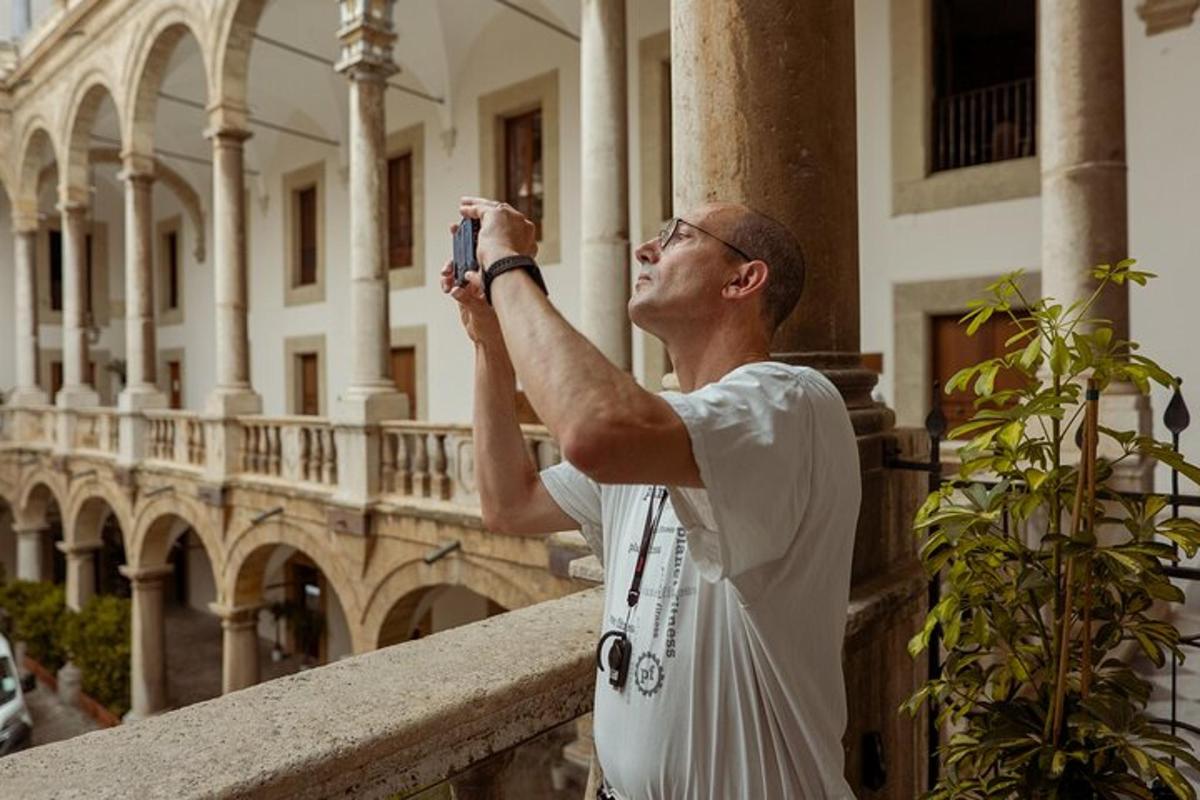 muž fotografující budovu fotoaparátem