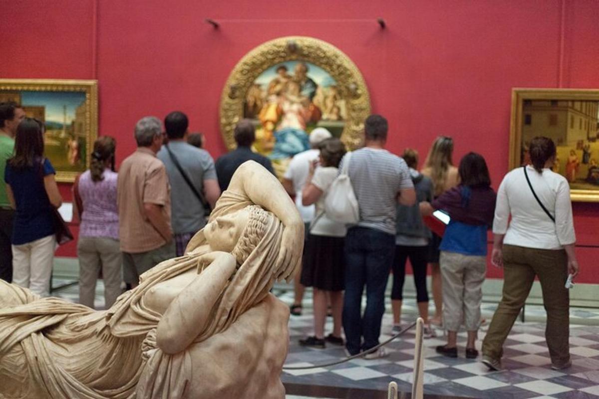 una folla di persone che guardano un dipinto in un museo