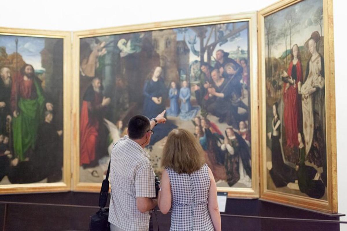 duas pessoas em pé em frente a uma pintura