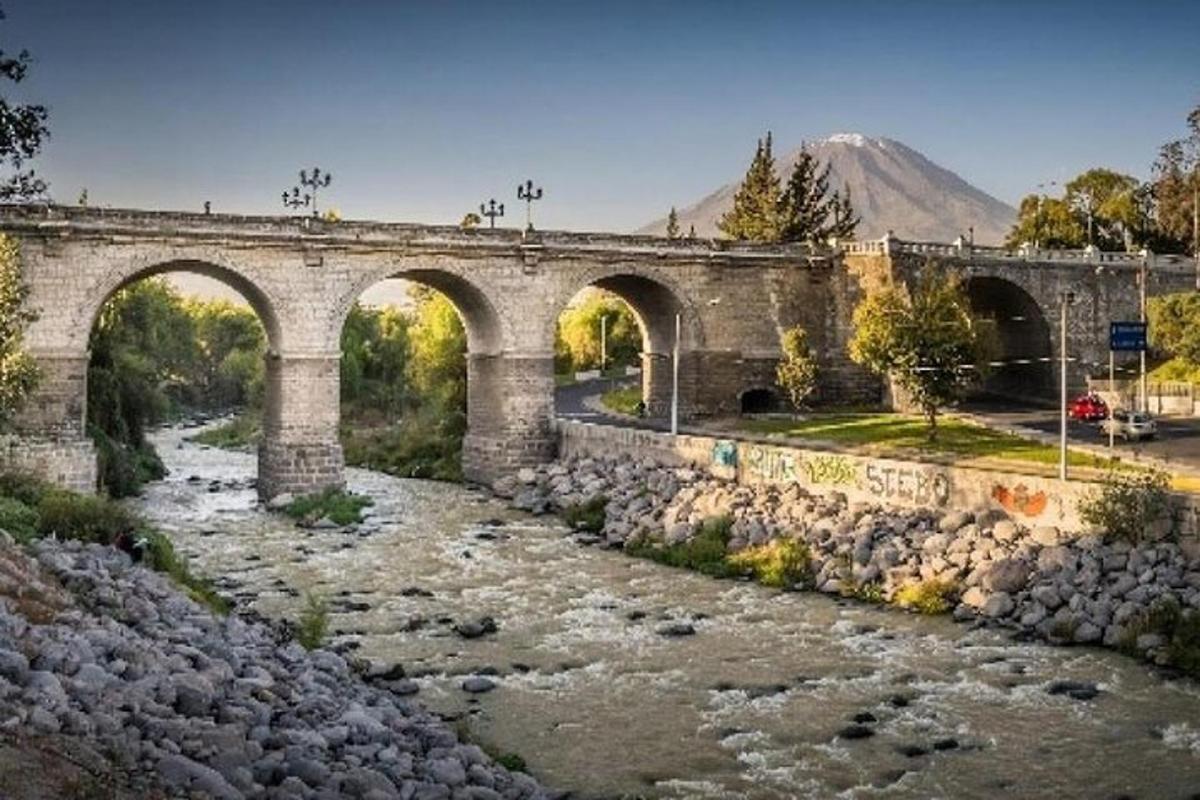 a stone bridge over a river with rocks