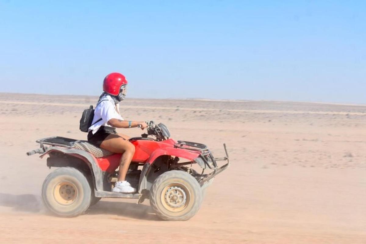 seorang lelaki menaiki atv merah di pantai