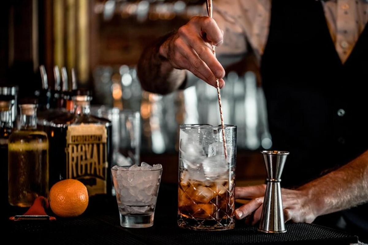 a person is stirring a drink in a glass