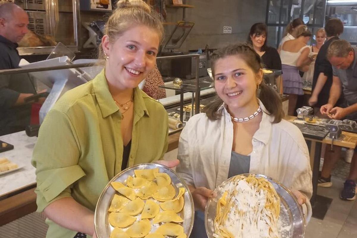 zwei Frauen stehen in einer Küche und halten Teller mit Essen