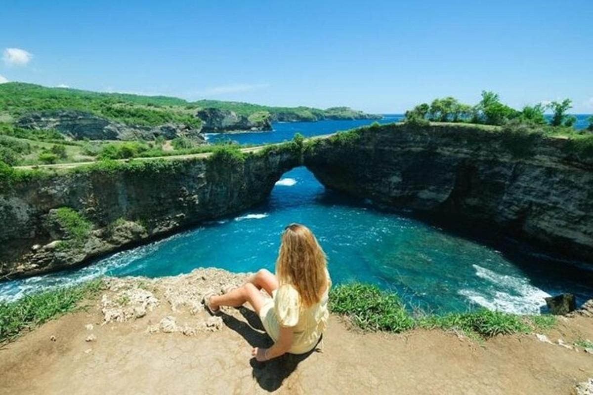 a woman sitting on a rock near a body of water