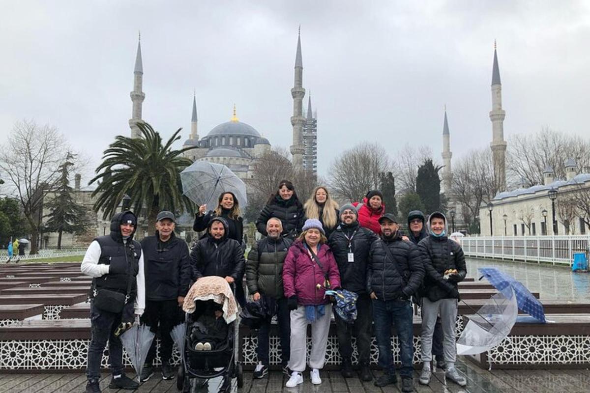 un gruppo di persone in posa davanti a una moschea
