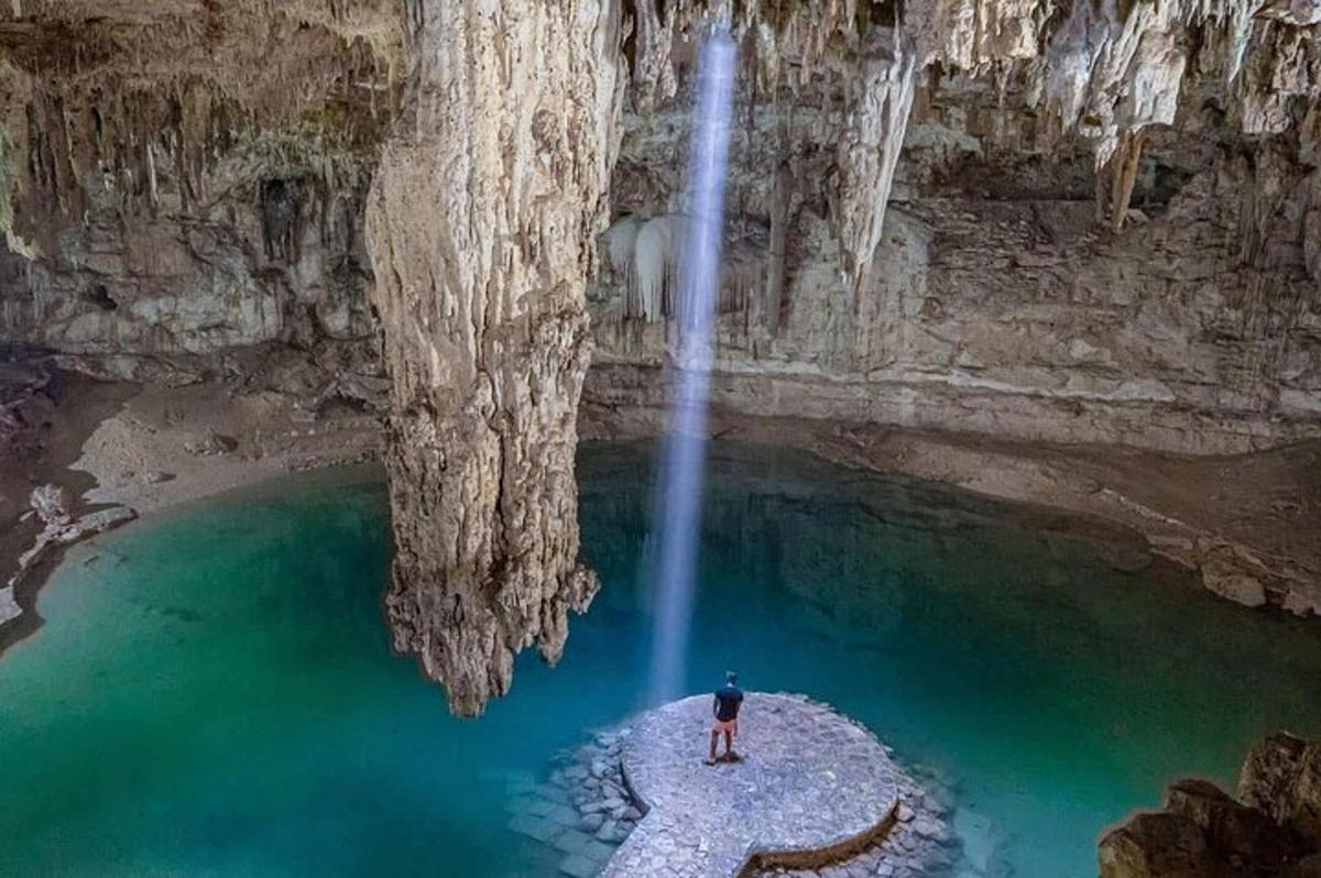 Ein Mann steht vor einem Wasserfall in einer Höhle