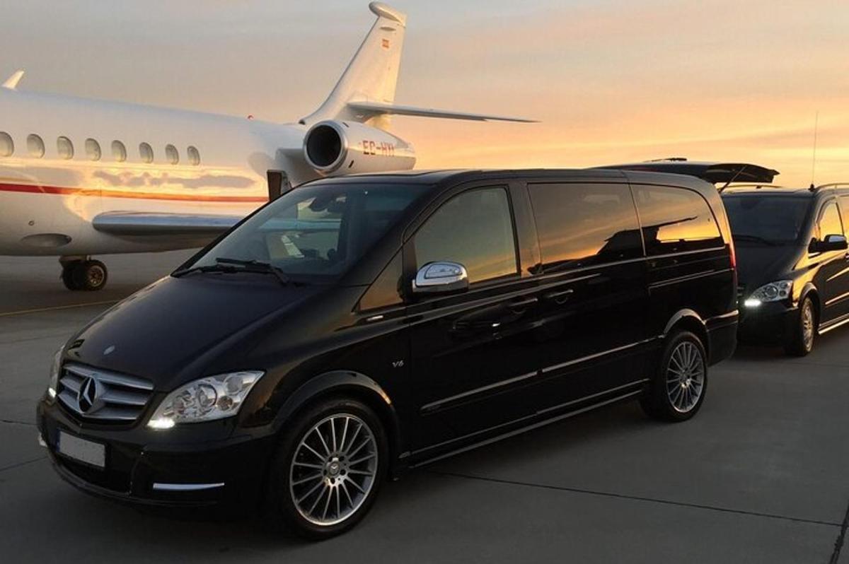 a black van is parked next to an airplane