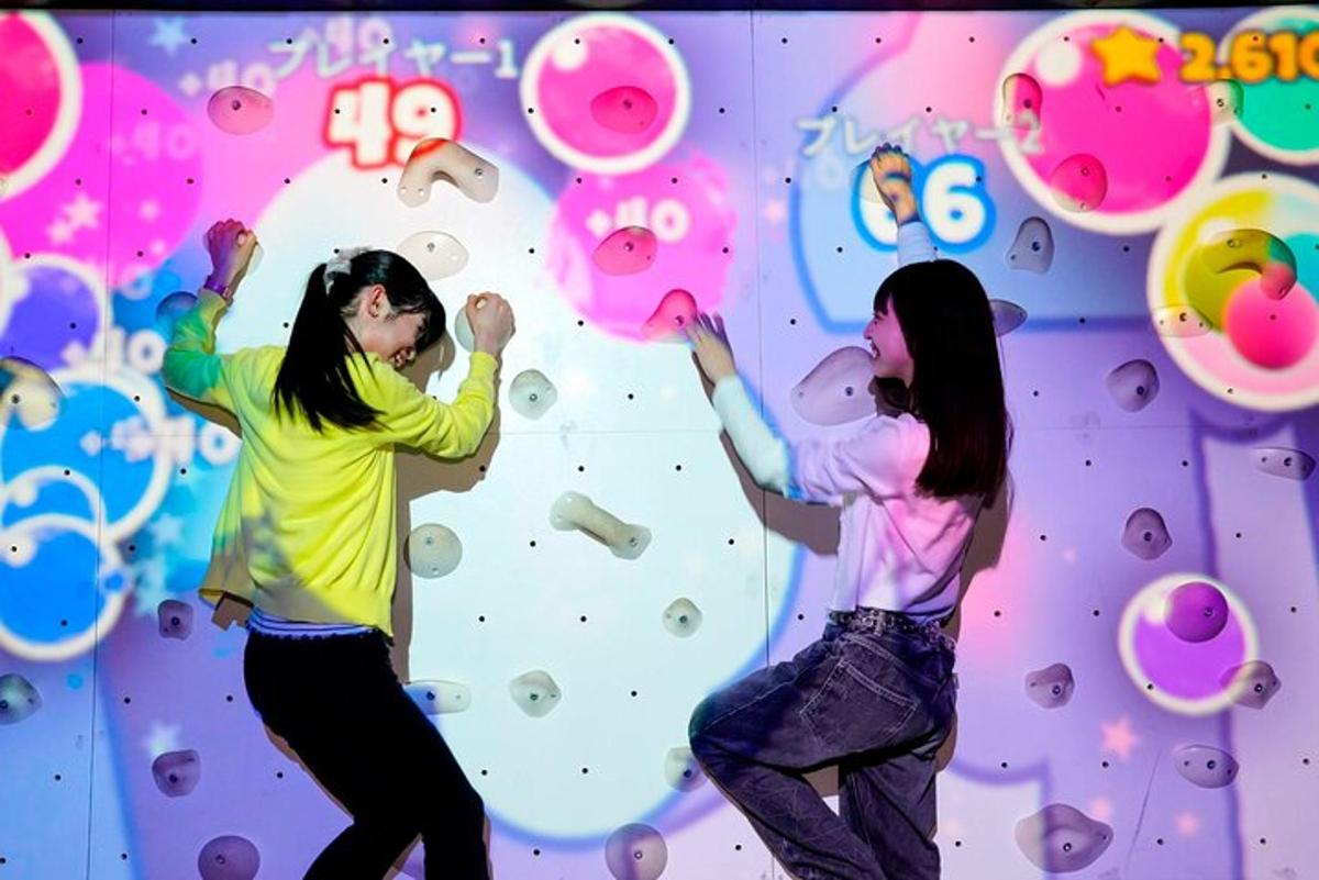 two people are climbing a climbing wall