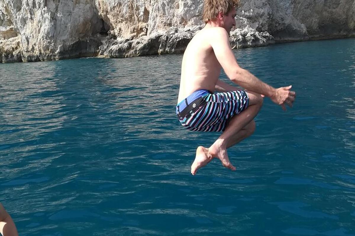ένας άντρας πηδάει στο νερό από μια βάρκα
