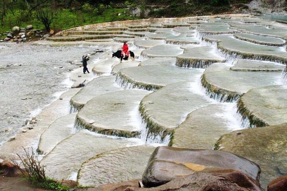 un gruppo di rocce con persone a cavallo nell'acqua