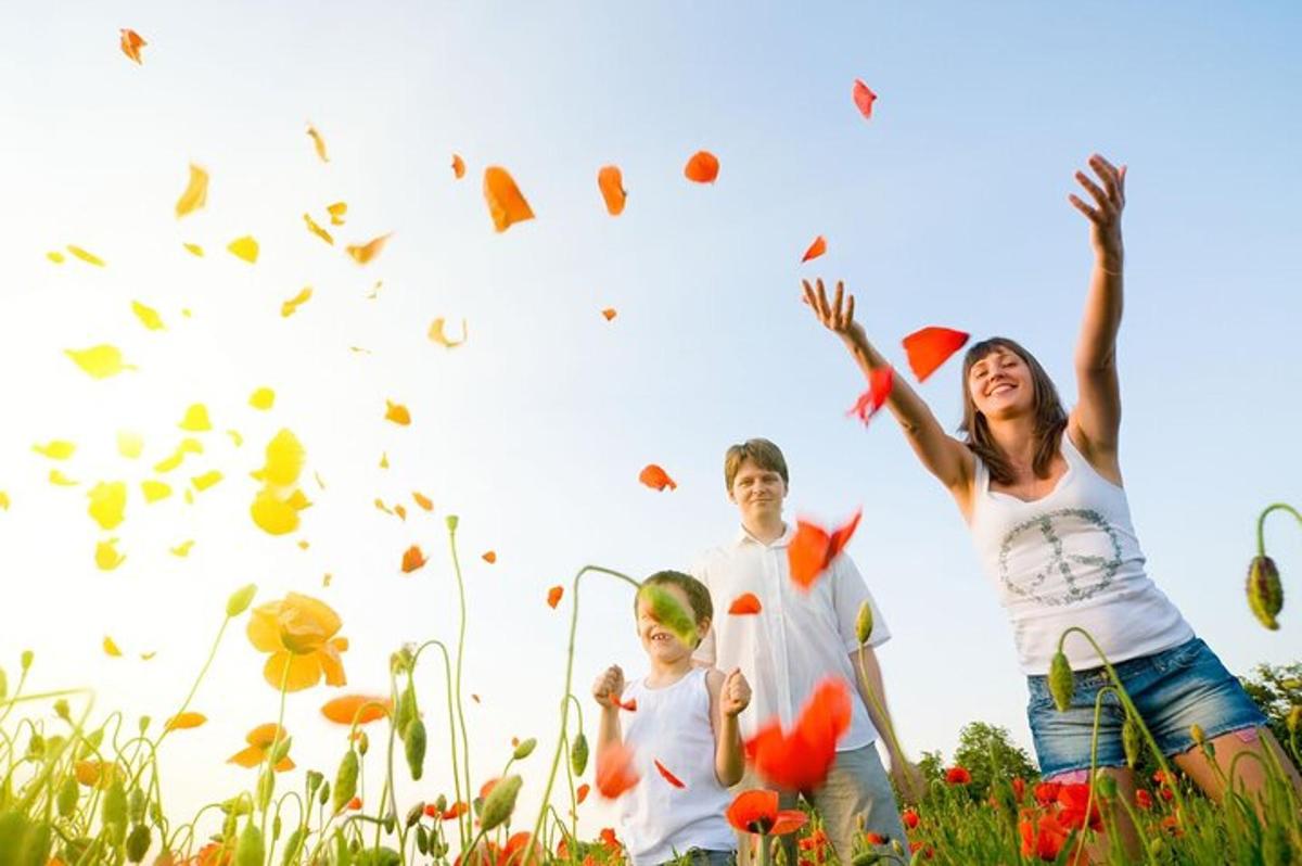 uma família brincando com folhas em um campo