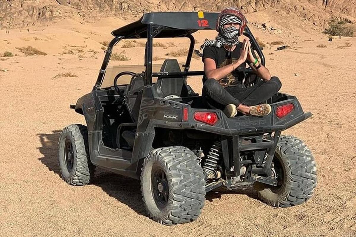 una persona seduta in un veicolo nel deserto