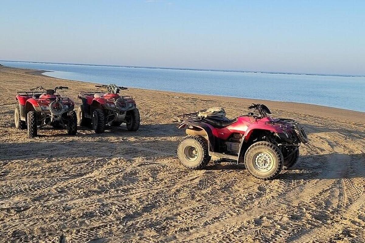 zwei ATVs Andanas an einem Sandstrand in der Nähe des Wassers