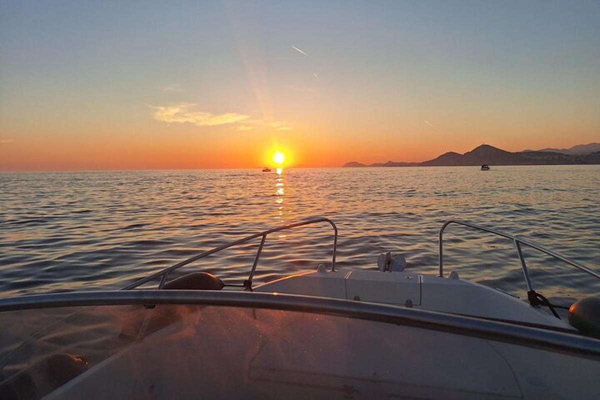 a boat in the water with the sunset in the background