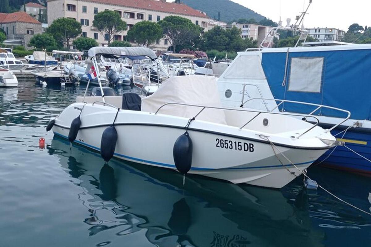 a white boat is docked in the water