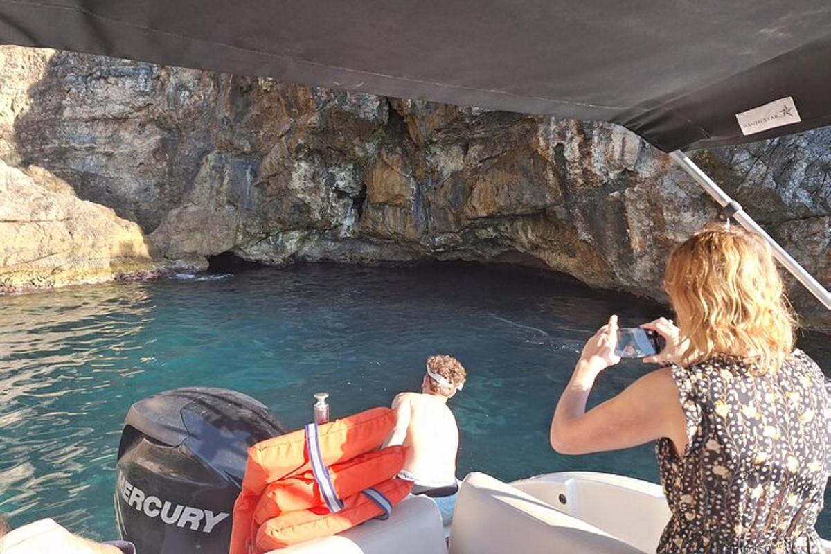 a woman taking a picture of a man in a boat in a cave
