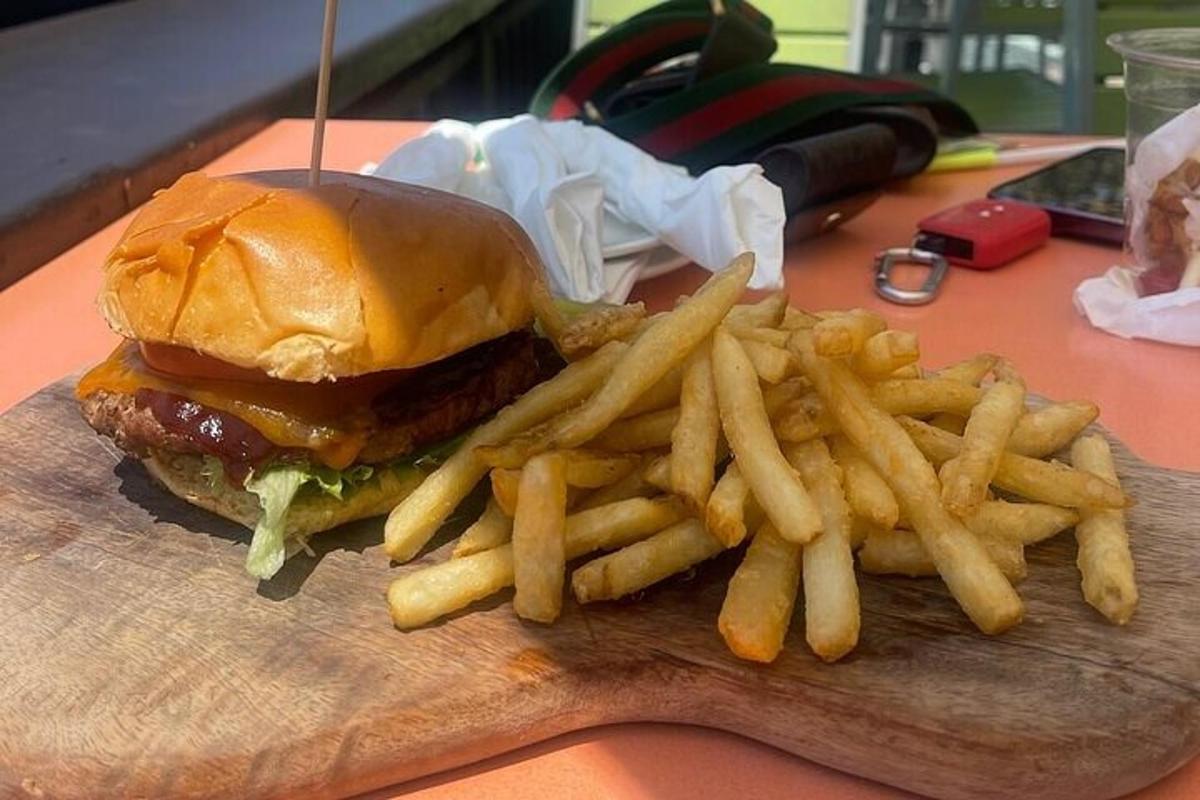 hamburger dan kentang goreng di atas papan pemotong kayu