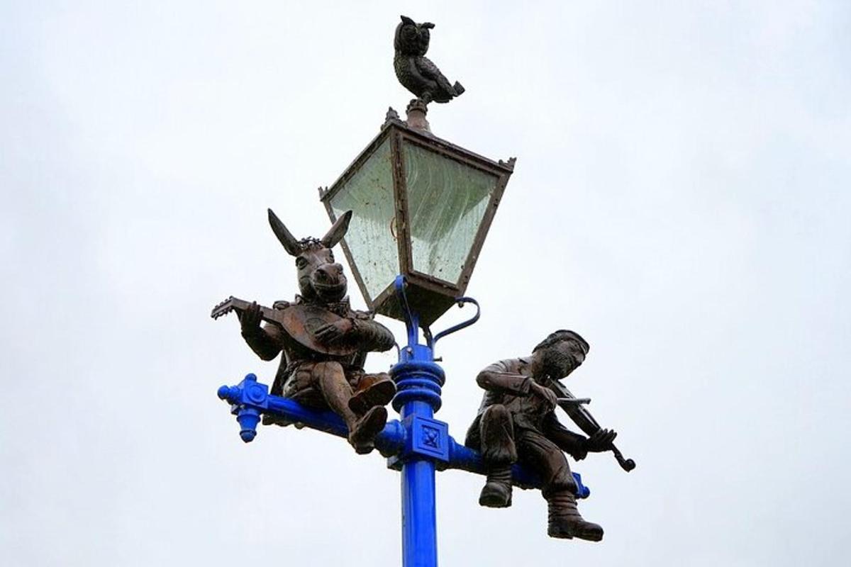 Una estatua de dos hombres encima de una farola.