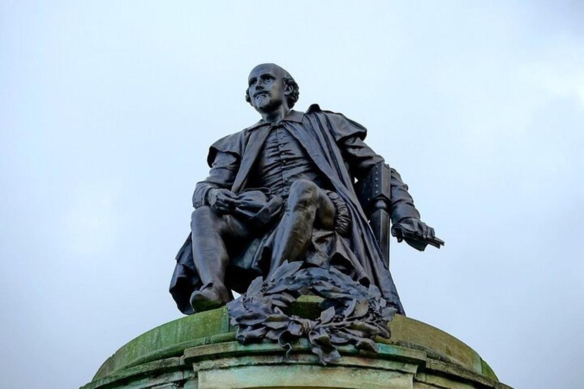 uma estátua de um homem sentado no topo de um prédio