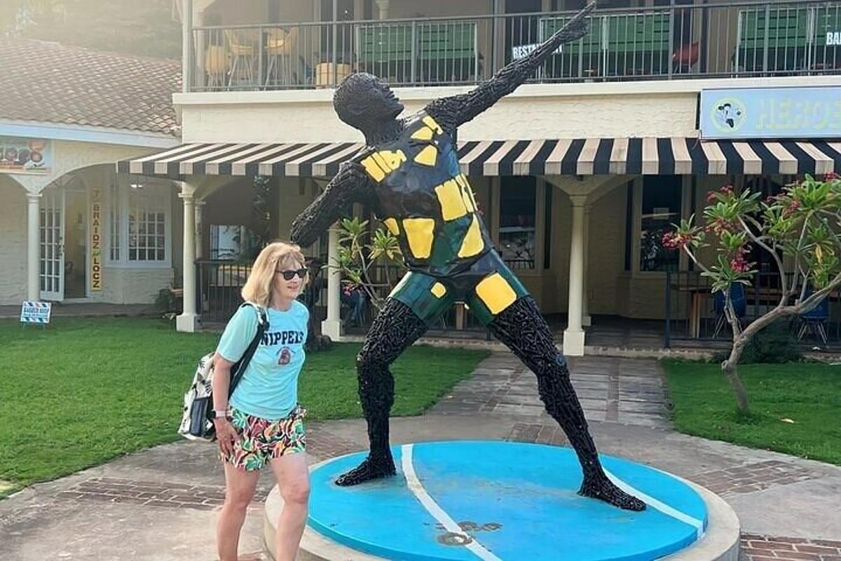 una donna in piedi accanto alla statua di un uomo