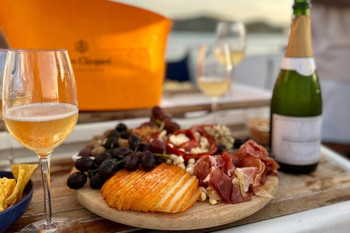 Una mesa con un plato de comida y una copa de vino.