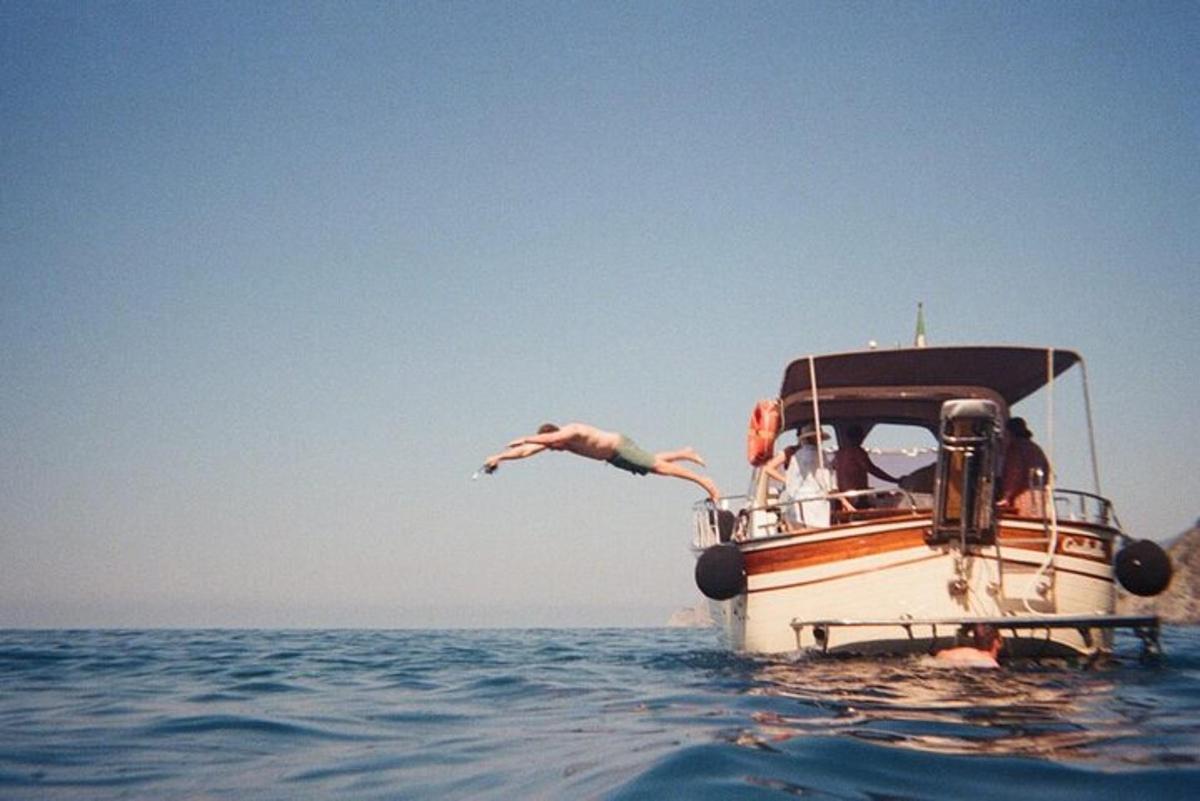 una persona che salta da una barca in acqua