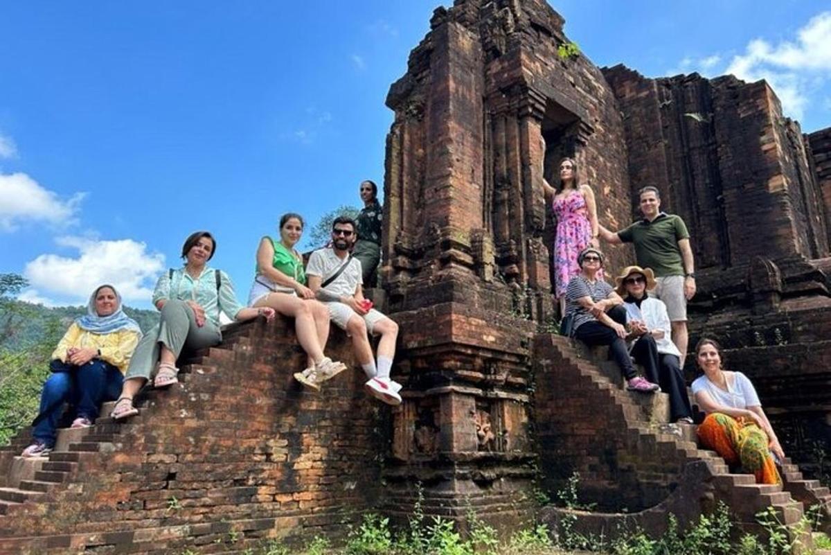 un grup de persones assegudes a les escales d'un edifici antic