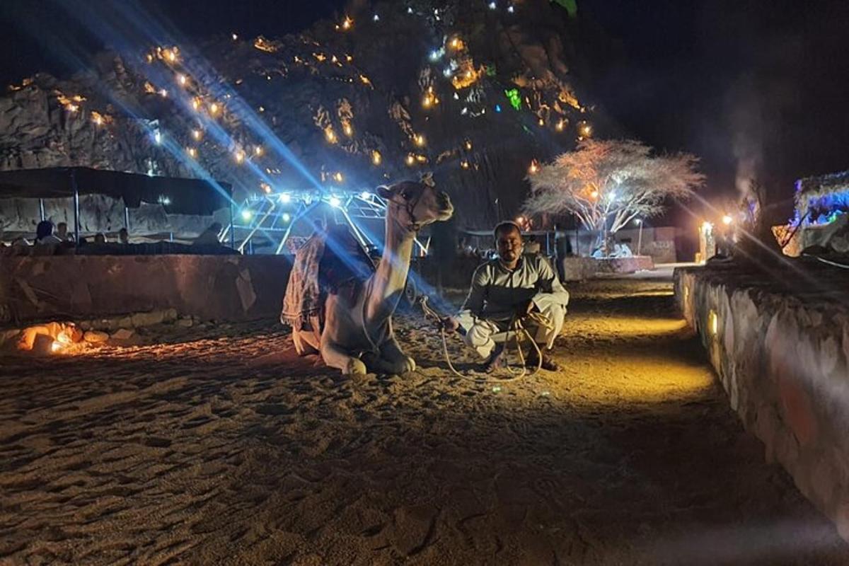 un uomo e una donna seduti sulla spiaggia di notte