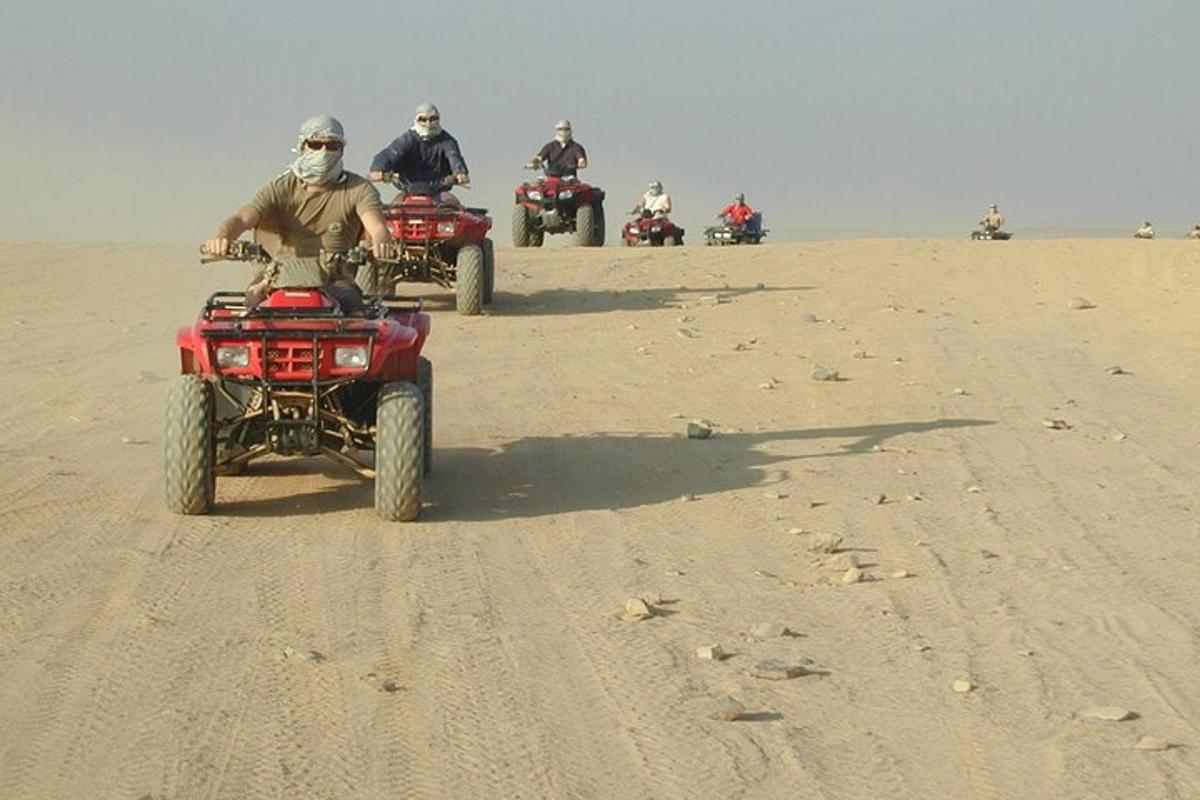 un gruppo di persone che guidano quad nel deserto