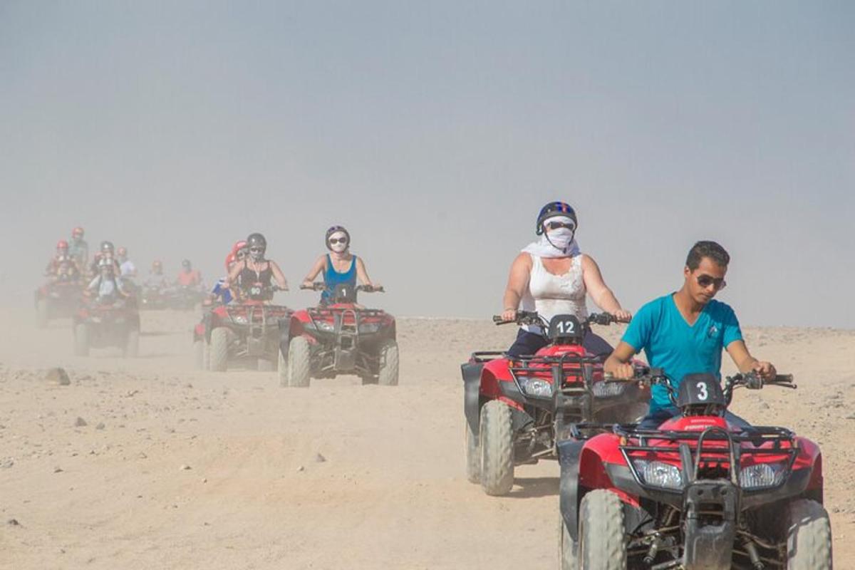 un gruppo di persone che guidano quad sulla sabbia