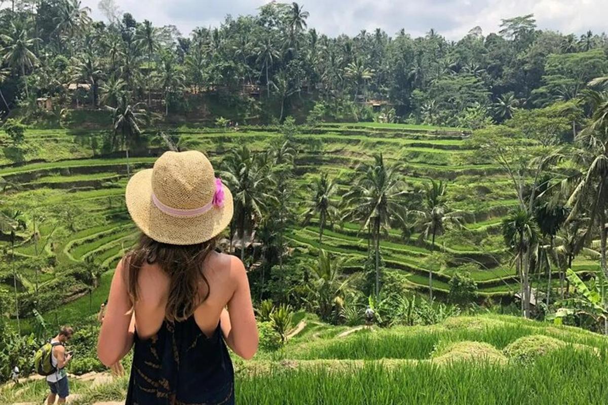 Una mujer con sombrero mirando un campo de arroz