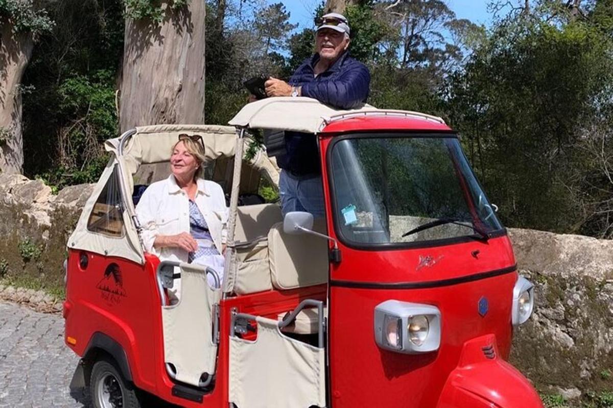 a man and a woman riding in a small car