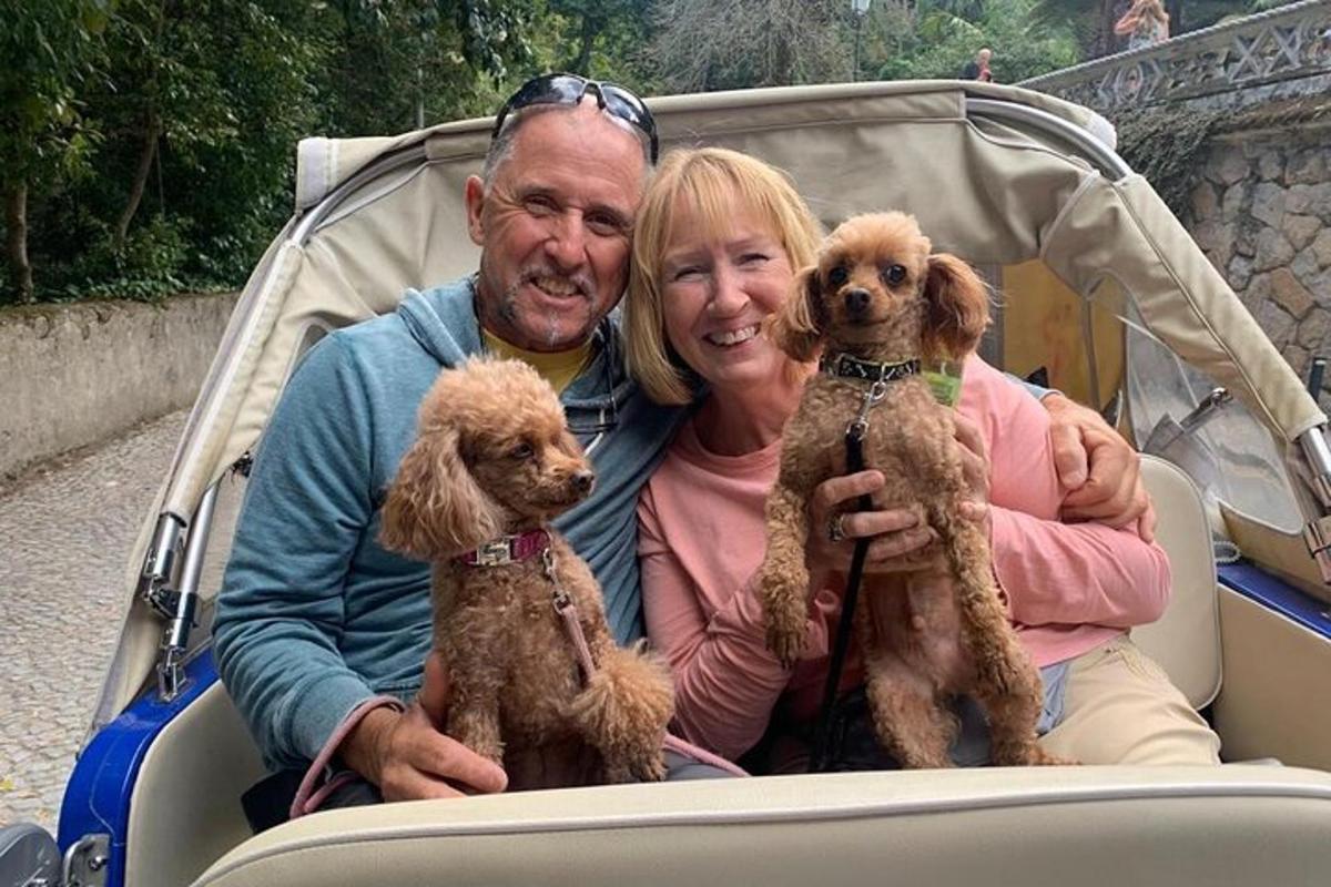 a man and a woman posing for a picture with two dogs