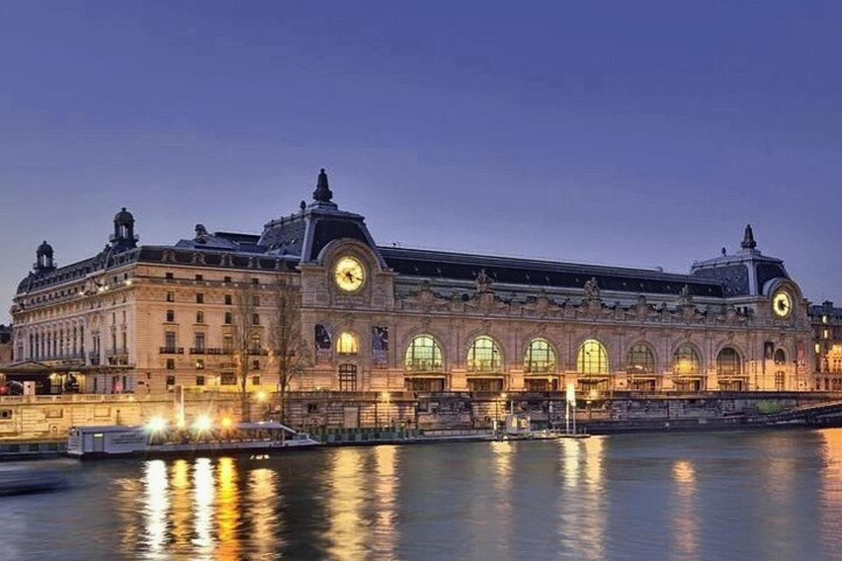 a large building with a clock on it next to the water