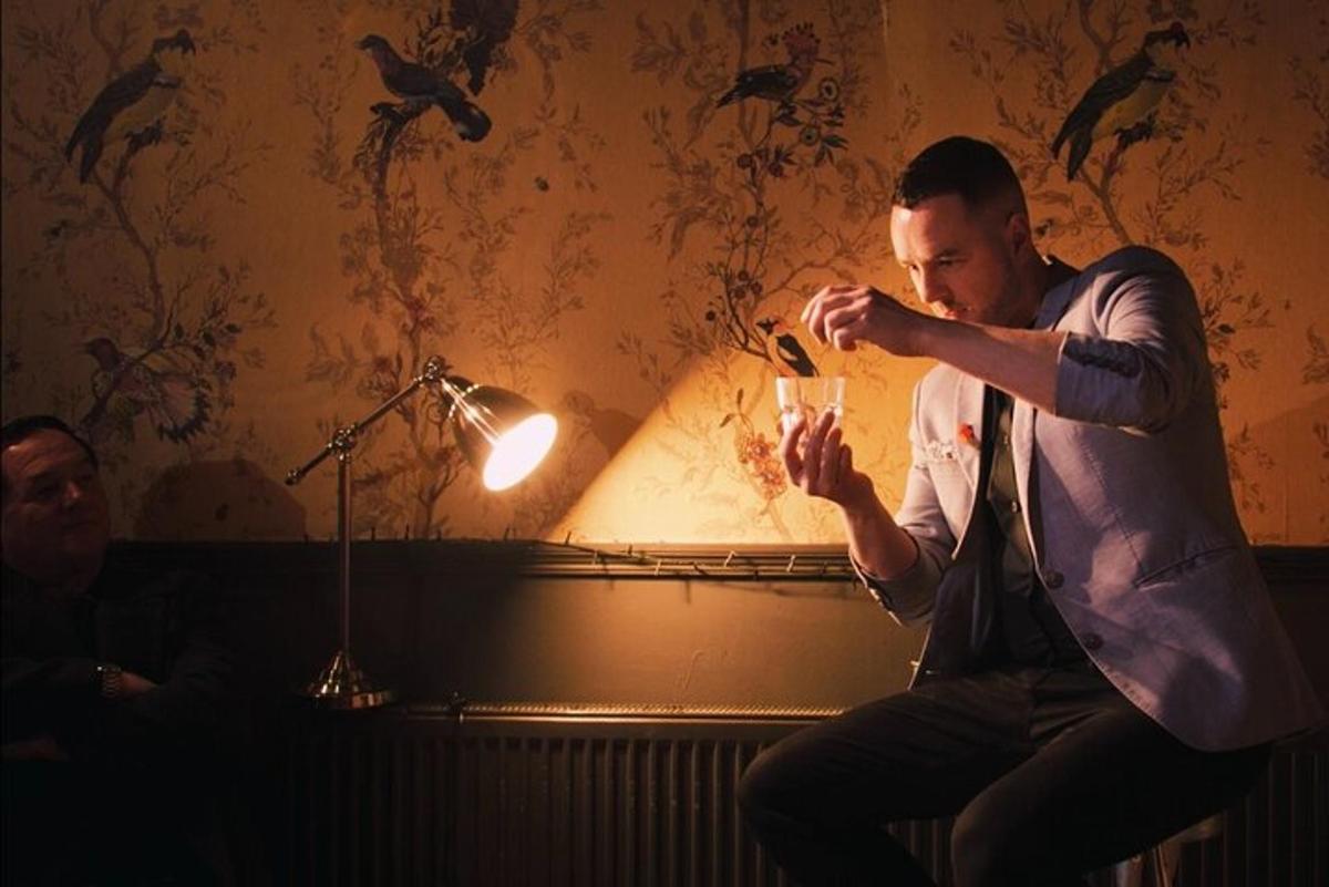 a man sitting on a couch drinking a drink