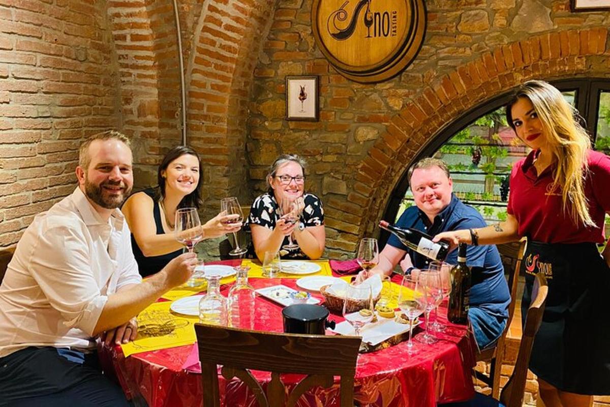 um grupo de pessoas sentadas ao redor de uma mesa com taças de vinho