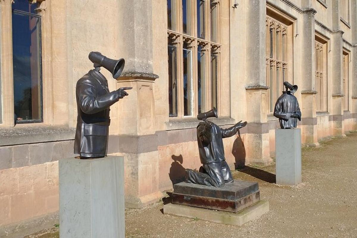 Dos estatuas de personas paradas frente a un edificio.